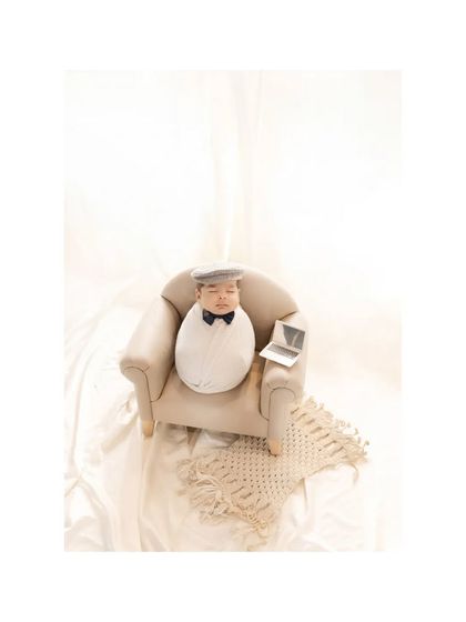 A wider angle of the "newborn boss" setup. The clean, bright studio background and simple props keep the focus on the charming and funny concept, creating a truly memorable photo.