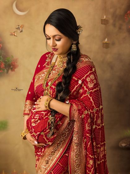 A close-up portrait focusing on the mother-to-be's gentle expression as she cradles her baby bump. Her traditional attire adds a layer of cultural richness to the moment.