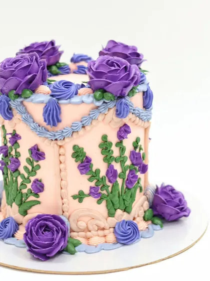 A close-up of the hand-piped purple buttercream roses and lavender sprigs.