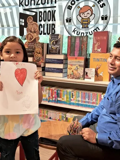 Making memories that last a lifetime. A young artist proudly shows her creation at our art corner, a space always open for doodling and creativity.