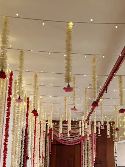 Another view of the ceiling decor with hanging floral strings and fairy lights. This setup creates a canopy effect over the doorway, making the entrance to the main event area feel special.
