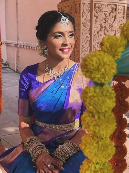This image showcases the complete look, with the beautiful saree and traditional jewelry. The makeup is kept elegant and timeless, letting the bride's natural beauty be the focus.