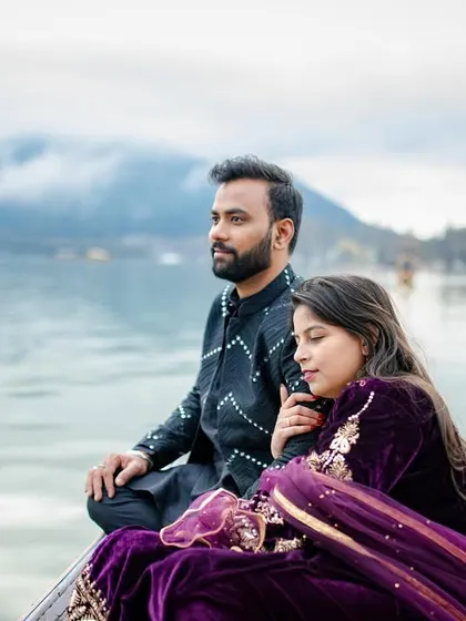 A serene and majestic shot of the couple on a Shikara boat in Dal Lake, Kashmir. The misty mountains in the background add a sense of peace and grandeur to this destination pre-wedding photo.