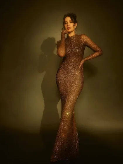 For her appearance on Jhalak Dikhhla Jaa, I put Nora Fatehi in this shimmering, form-fitting gown by Itrh. The ruched fabric and built-in gloves create a sophisticated and high-fashion television look.