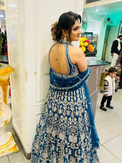 The backless design of this peacock blue lehenga adds a touch of glamour. It’s a perfect example of the stylish and affordable designer lehengas you can rent.