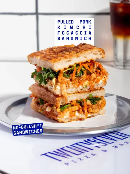 A stacked view of the Pulled Pork Kimchi Focaccia sandwich, showing how much filling is packed into each one. These are substantial, satisfying sandwiches.