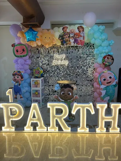 This view of Parth's party shows the 'one' block and another Cocomelon character, adding more themed elements to the decor.