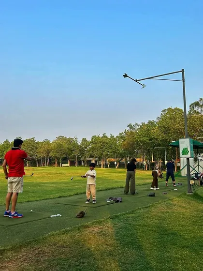 A father and son practice together, showing that golf is a game for all generations.
