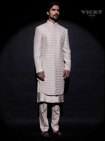 A full-length view of our layered sherwani, showcasing the elegant fall of the fabric and the precision of its cut. This ensemble is designed for a grand and statuesque presence.