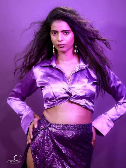 A strong, hands-on-hips pose that exudes power and attitude. The purple light creates a cool, edgy vibe.
