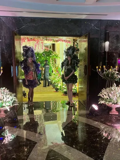 Welcoming artists at the entrance of a grand event. These performers in elaborate costumes add a touch of glamour and make for a great photo opportunity as guests arrive.