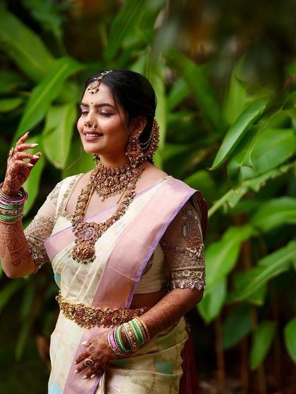 A bride in a pastel green and pink saree with a sheer, embroidered blouse. The look is fresh, modern, and elegant.