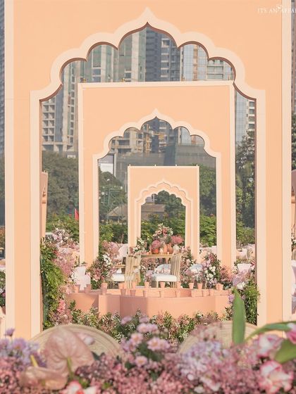 A 'Handpainted Story' wedding theme, using layered, hand-painted arches in shades of peach and pink to create a sense of depth and perspective.