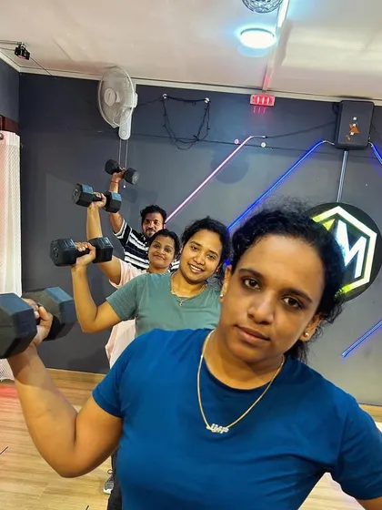 A snapshot of a group showing off their strength after a tough dumbbell workout. Pushing your limits is always more fun when you have a team cheering you on.