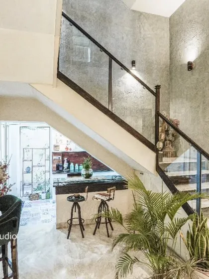 A view of the staircase from image 23, showing the under-stair bar area with velvet chairs.