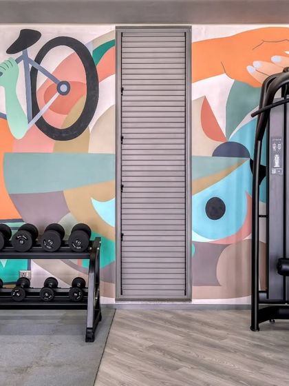 A detail of the gym mural, showing how it wraps around the fitness equipment. The color palette of teals, oranges, and pastels is both uplifting and sophisticated.