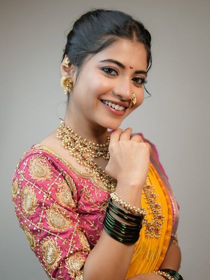 A classic Maharashtrian look with a simple, graceful touch. We used nude tones for the makeup to complement the timeless saree and pastel floral bun.