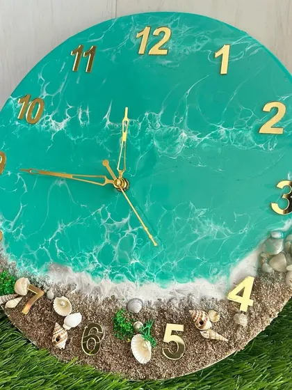 A bright and cheerful ocean clock with turquoise water and a sandy beach with fun shell details.