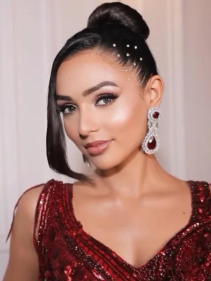 This is full diva mode. A sleek top-knot bun with scattered rhinestones for that extra bling, paired with a bold, dramatic eye. This look is made for dancing the night away.
