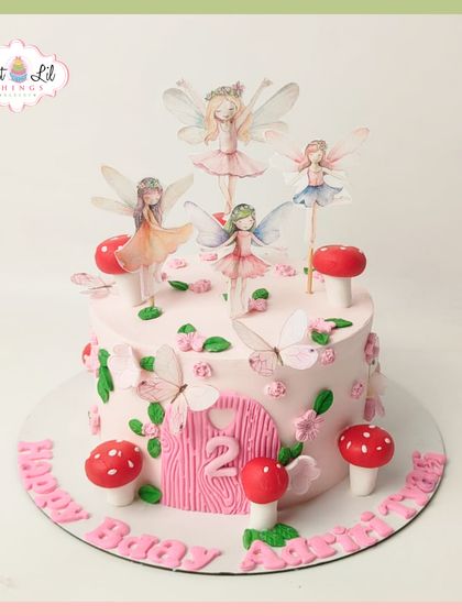 An enchanted forest comes to life on this fairy-themed cake for a 2nd birthday. It features a fairy door, whimsical mushrooms, and delicate fairy toppers for a truly magical party.