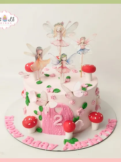 An enchanted forest comes to life on this fairy-themed cake for a 2nd birthday. It features a fairy door, whimsical mushrooms, and delicate fairy toppers for a truly magical party.