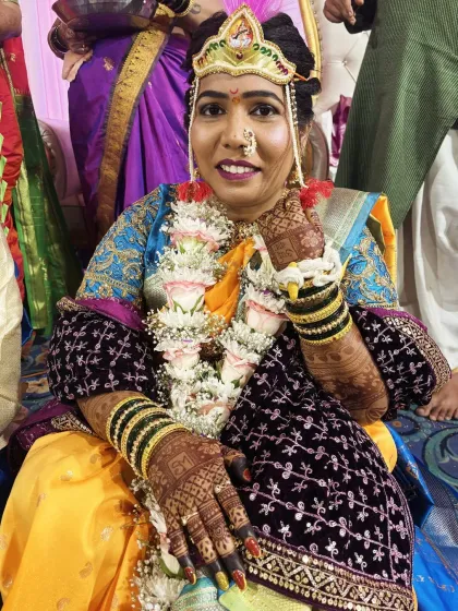A happy Marathi bride on her wedding day. Her hands are adorned with traditional, intricate mehendi that complements her bridal attire perfectly.