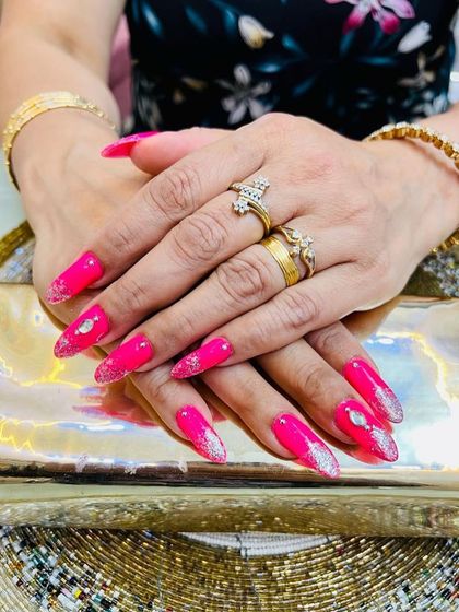 The sharp, stiletto shape of these nails combined with the bright pink and sparkle is pure drama.