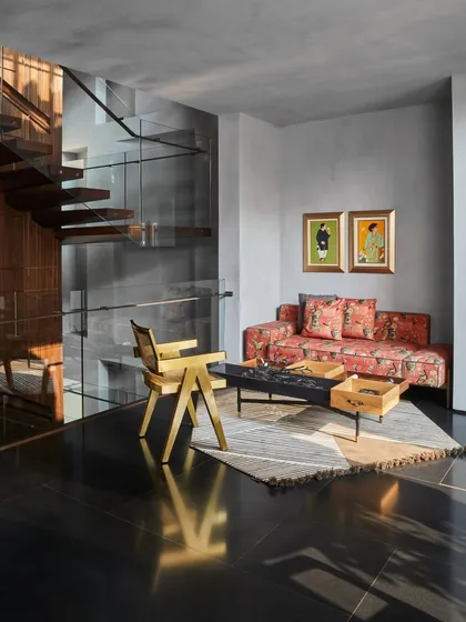A floating staircase with glass railings at the Baid Residence. This design creates a sense of openness and transparency, allowing light and views to flow uninterrupted through the space.
