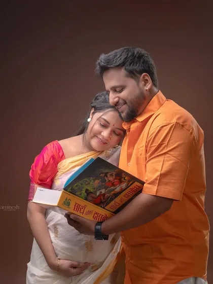 We can incorporate meaningful cultural elements into your maternity session. Here, this couple shares a quiet moment with a traditional Marathi book, blending their heritage with the excitement of their new beginning.