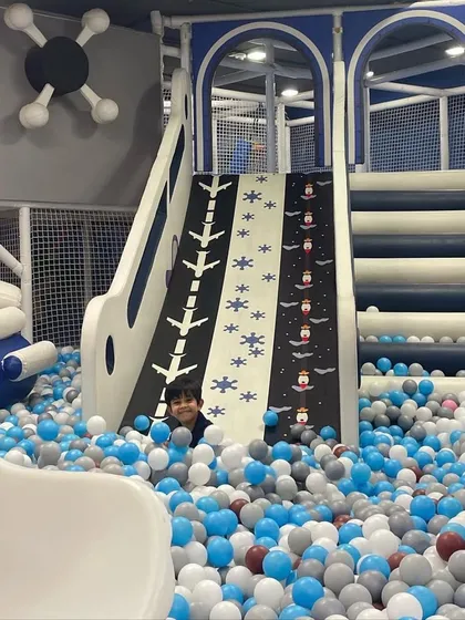 Peeking out from a mountain of fun! The ball pit offers endless opportunities for games like hide and seek.