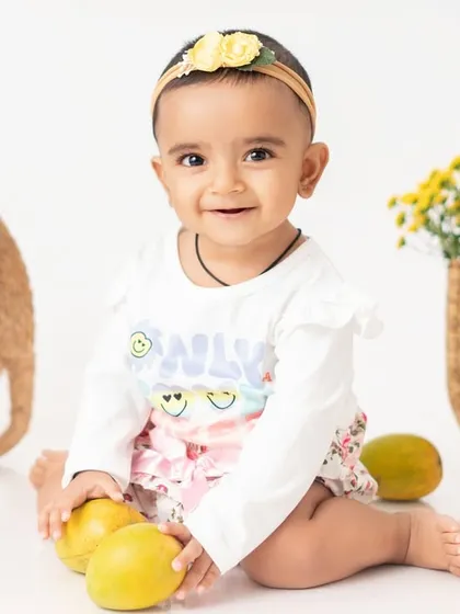 A close up of the birthday girl with her mangoes. Her happy expression shows just how much she enjoyed this personalized and fun photoshoot theme.