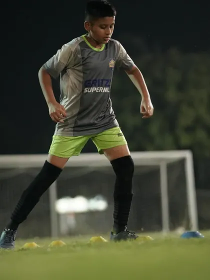 A young player focused on his footwork during a cone drill. Mastering these basics is essential for controlling the game.