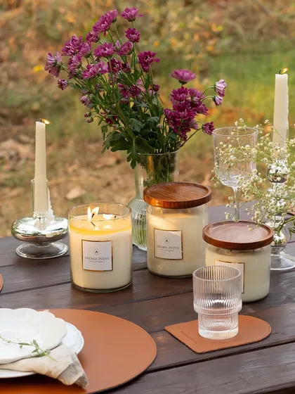 An outdoor dining table set with an array of our glass jar and taper candles. The flickering flames create a dynamic and inviting centerpiece, proving that layering candlelight is key to a magical atmosphere.