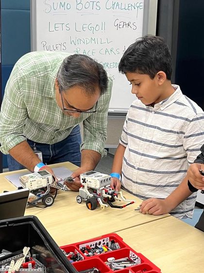A father and son work together on a robot during one of my events. I love creating opportunities for families to learn and build together, making technology a shared passion.