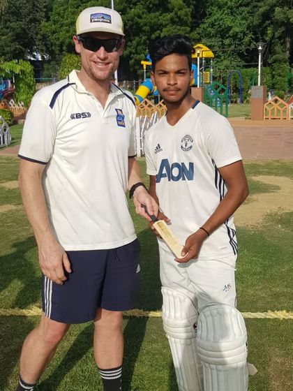 One of my senior players standing with a cricketer from New Zealand. This exposure is crucial for players aiming for a professional career.