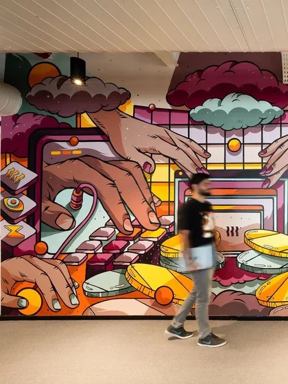A shot of a team member walking past the mural, giving a sense of its impressive scale.