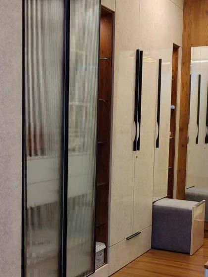 This wardrobe holds a clever secret. I designed it with a hidden, tucked-in pouf that can be pulled out for a comfortable seat at the vanity, making it a perfect example of smart, space-saving design.