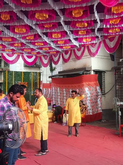 My team and guests at a Haldi event, with the colorful pandal ceiling above. I am always on-site to manage the event.