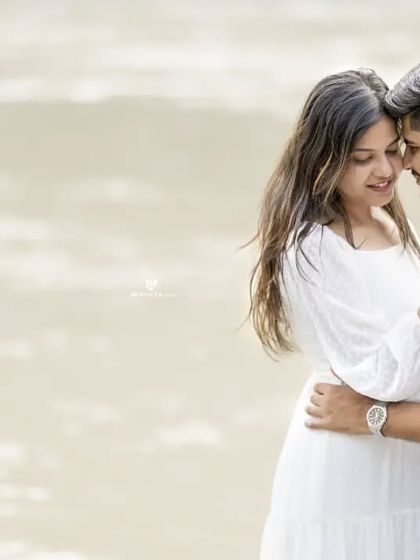 A close-up, intimate embrace on the beach. The soft focus and natural expressions make this a very romantic and heartfelt image.