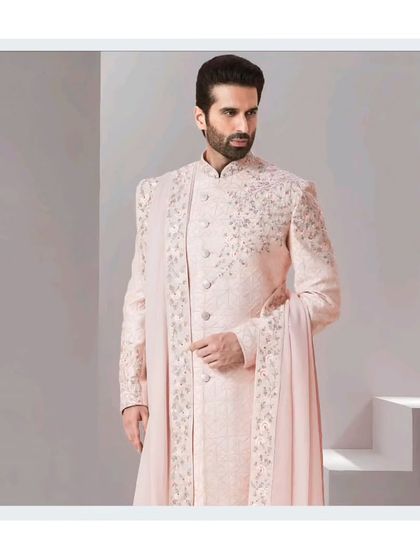 A professional shot of a model in our elegant pastel pink sherwani. This is a perfect choice for the groom who wants a subtle yet luxurious look.