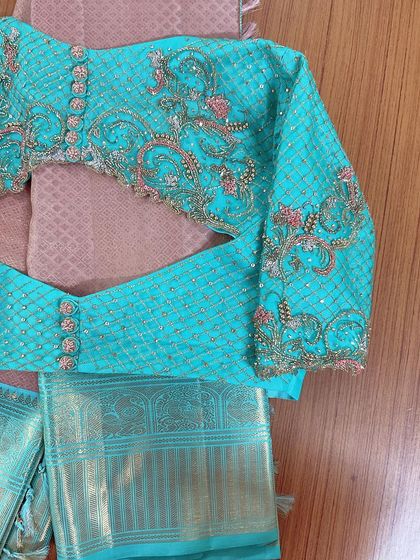 A modern twist to the classic Kanjeevaram saree blouse. This turquoise piece features intricate zardosi work in a lattice pattern on the sleeves.