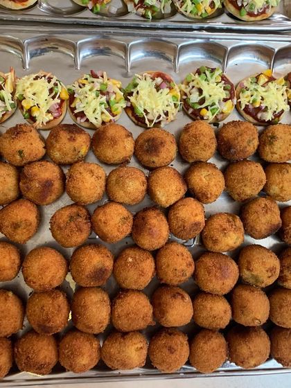 Trays of mini pizzas and corn cheese balls, freshly made for a party of 40. Bite-sized snacks are perfect for mingling.