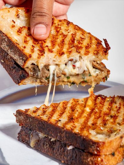 The iconic cheese pull of our Cheesy Mushroom Melt, a testament to our commitment to using quality ingredients.