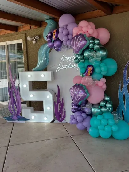 Another angle of the mermaid party, highlighting the vibrant balloon colors and the glowing marquee number.