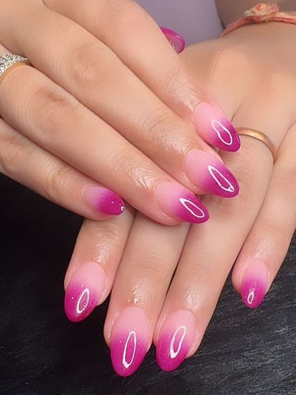 A vibrant pink ombré manicure, fading from a soft nude to a bright magenta.