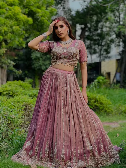 A full-length view of the mauve pleated lehenga. This is a unique and stylish option for a wedding guest who wants to stand out.