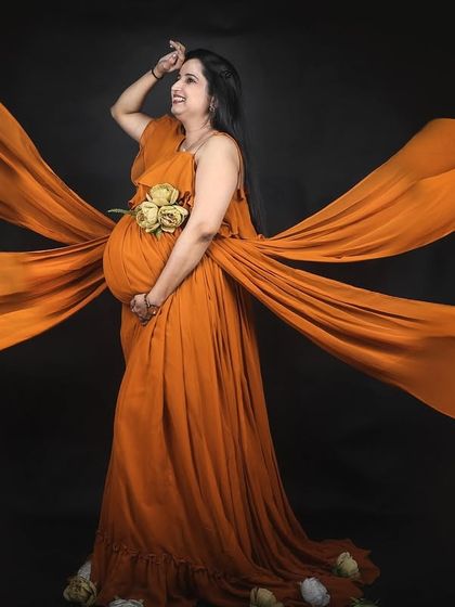This studio shot showcases the incredible spread of our mustard four-trail gown against a black background, highlighting the color and dramatic flow of the fabric.
