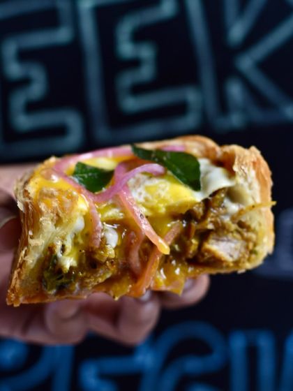 A bite of our Mutton Pepper Fry Puff Pie, showing the rich filling and flaky crust. This was a weekend special that our guests couldn't get enough of.