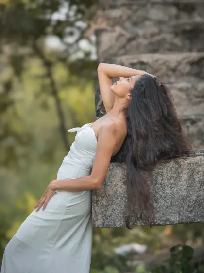 An editorial-style bridal portrait that plays with lines and posture. The stone background and the model's pose create a strong, high-fashion look.