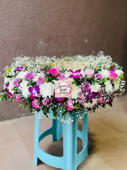 A fresh flower basket for a 'Jawal' ceremony (baby's first haircut). This large, decorative basket is filled with a mix of colorful flowers.